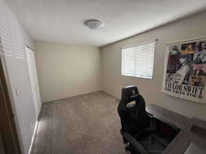 Carpeted office space with a textured ceiling