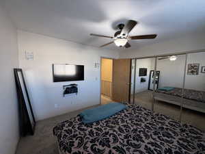Bedroom featuring carpet, a ceiling fan, and a closet