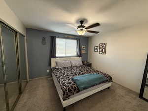 Bedroom with a closet, carpet, a textured ceiling, and a ceiling fan