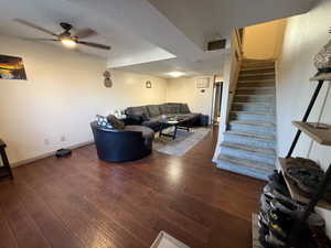 Living area featuring wood-type flooring, stairway, a ceiling fan, and baseboards