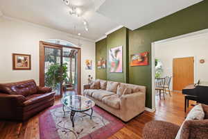 Living area with wood-type flooring and ornamental molding