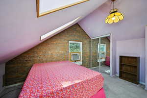 Bedroom featuring vaulted ceiling, carpet floors, cooling unit, and a closet