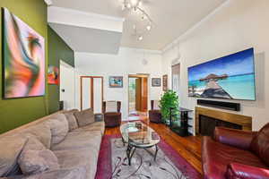 Living room with hardwood / wood-style floors and ornamental molding