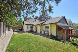 Back of property featuring a patio, ac unit, stucco siding, and a shingled roof