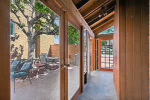 Entryway featuring french doors, lofted ceiling, and wood walls