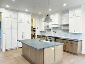 Kitchen with open shelves, light wood finished floors, tasteful backsplash, hanging light fixtures, and recessed lighting
