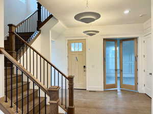 Foyer with light wood-type flooring, stairs, and french doors