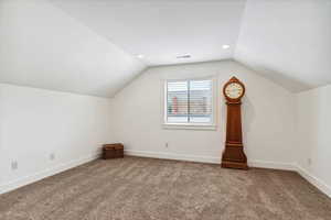 Additional living space featuring lofted ceiling, carpet flooring, baseboards, and recessed lighting