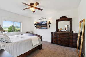 Bedroom with carpet floors, a ceiling fan, and baseboards