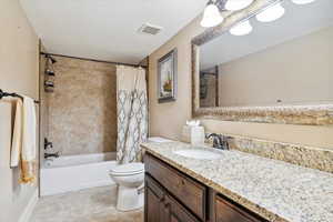 Bathroom featuring toilet, vanity, shower / bathtub combination with curtain, and tile patterned flooring