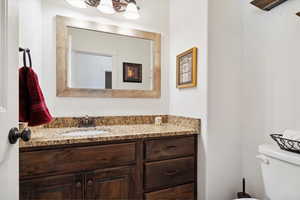 Half bathroom featuring vanity and toilet