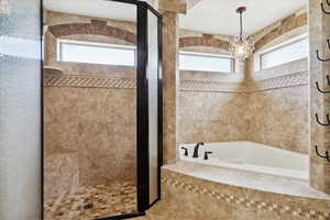 Bathroom featuring a stall shower, a bath, and plenty of natural light