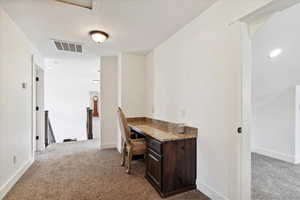 Carpeted office space with baseboards