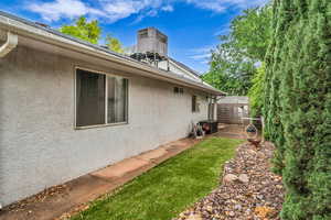 View of property exterior with stucco siding and fence