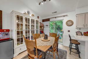 Dining room with vaulted ceiling and light tile patterned floors