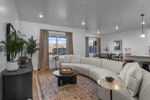 Living room with light wood-type flooring, recessed lighting, and baseboards