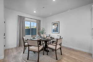 Dining room with light wood-style floors, baseboards, and recessed lighting
