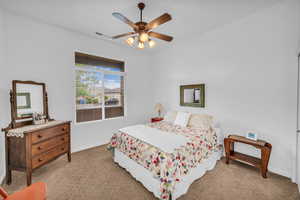 Carpeted bedroom with baseboards and a ceiling fan