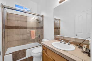 Full bath featuring toilet, shower / bath combination with glass door, vanity, and wood finished floors