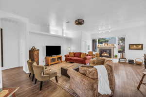 Living area featuring hardwood / wood-style floors, a tiled fireplace, and baseboards