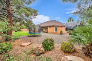 Back of house featuring a trampoline, stucco siding, a tile roof, and a patio