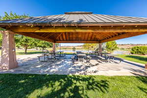 View of property's community with a gazebo, a water view, and a yard
