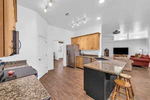 Kitchen with stainless steel appliances, a sink, a peninsula, a kitchen bar, and rail lighting