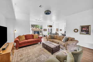 Living room with wood finished floors, baseboards, and a tiled fireplace