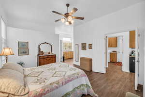 Bedroom featuring wood finished floors, connected bathroom, and ceiling fan