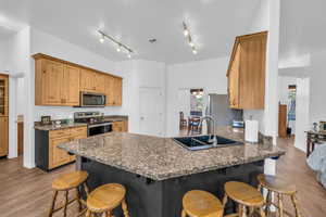 Kitchen featuring appliances with stainless steel finishes, a sink, a breakfast bar area, and a peninsula