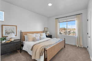 Carpeted bedroom with multiple windows and baseboards