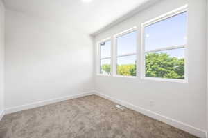 Carpeted empty room featuring baseboards