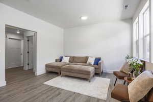 Living room featuring wood finished floors, baseboards, and recessed lighting