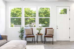 Sitting room featuring plenty of natural light, wood finished floors, and baseboards