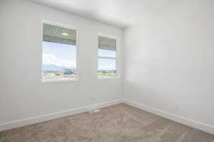 Carpeted spare room featuring baseboards
