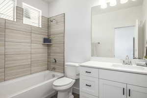 Bathroom featuring toilet, tub / shower combination, vanity, and wood finished floors