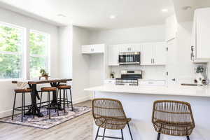Kitchen featuring appliances with stainless steel finishes, a sink, light wood-style flooring, healthy amount of natural light, and recessed lighting