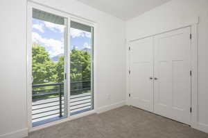 Unfurnished bedroom featuring carpet flooring, multiple windows, baseboards, and a closet