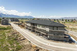 Back of house with a mountain view, a shingled roof, and a residential view