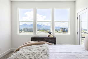Carpeted bedroom featuring baseboards and a mountain view