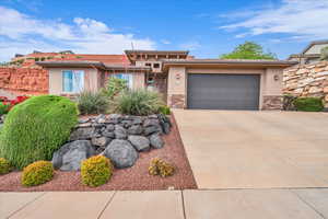 View of front of property with stucco siding, stone siding, driveway, a garage, and a tile roof