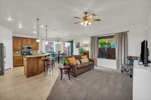 Living area with a ceiling fan, light tile patterned flooring, a chandelier, and recessed lighting
