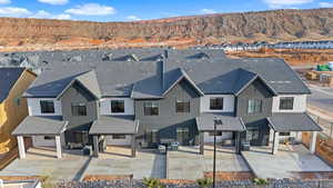 View of front of house with a mountain view, stucco siding, a patio area, and an outdoor living space