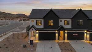 View of front of home featuring a garage, stucco siding, driveway, and a mountain view