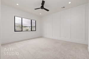 Spare room featuring a decorative wall, light colored carpet, recessed lighting, and ceiling fan