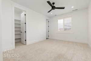 Unfurnished bedroom with carpet, recessed lighting, baseboards, a walk in closet, and a ceiling fan
