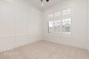 Unfurnished room featuring light carpet, baseboards, a decorative wall, and recessed lighting