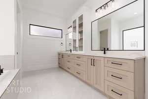 Full bath with double vanity and marble look tile flooring