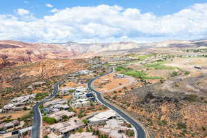 Aerial view of property and surrounding area featuring a mountainous background and nearby suburban area