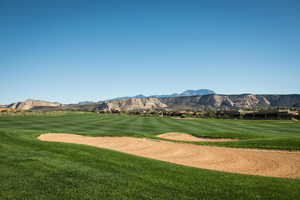 View of property's community featuring a mountain view, view of golf course, and a yard